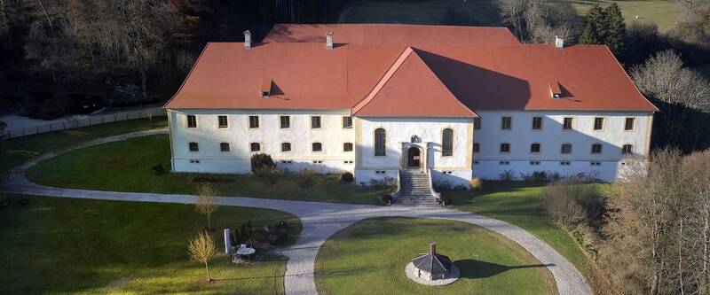 Blick auf Schloss Ehrenfels mit Vorgarten aus der Luft, umgeben von kahlen Bäumen.