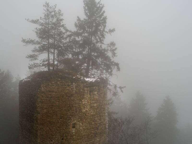 Blick auf die Ruine Hohenerpfingen aus der Luft bei dichtem Nebel im Winter.