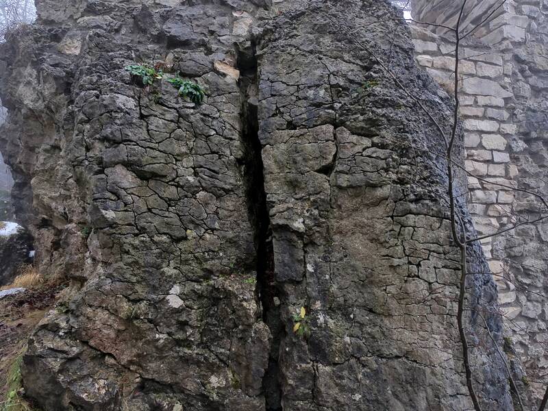 Felswand von Ruine Hohenerpfingen mit einem Spalt im Fokus bei Nebel im Winter.