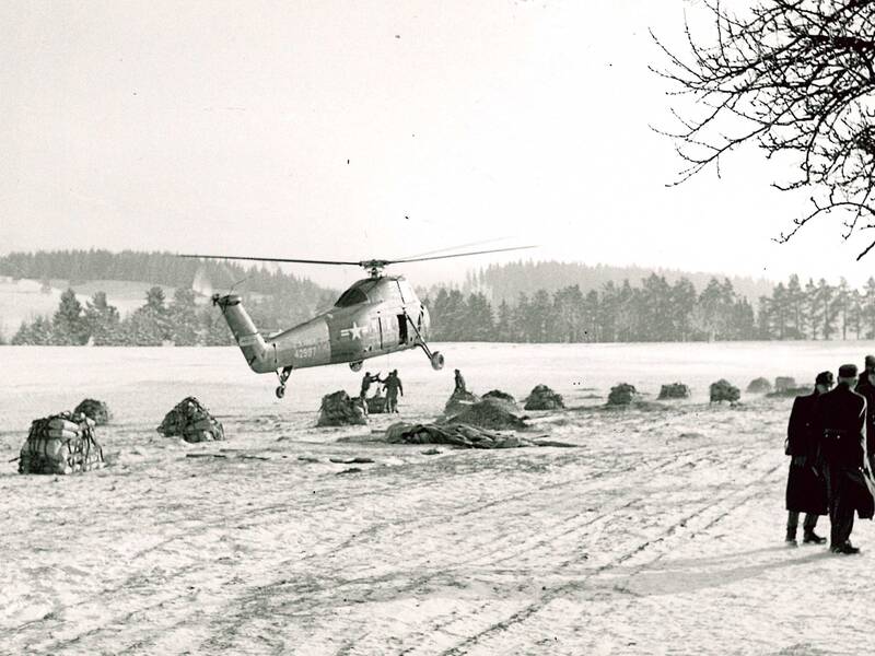 Bereitstellung von Baumaterialien auf dem Heersberg bei Burgfelden zum Abtransport durch Hubschrauber der US-Armee zur Ruine der Burg Schalksburg im Dezember 1957.
